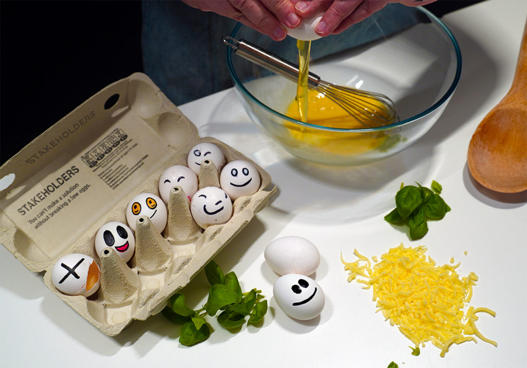 Eggs with smiley faces represent the stakeholders and members of a project team. 